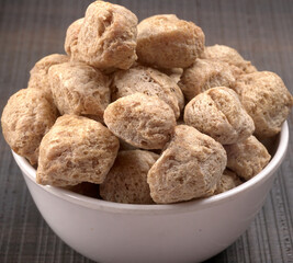 Raw soya chunks on dark background. Healthy, nutritious soybean meat, chunks isolated.Vegan food concept.