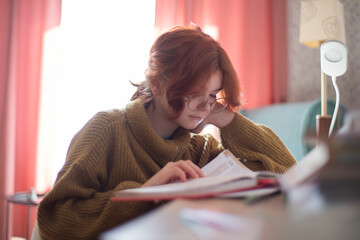 schoolgirl with glasses doing homework.