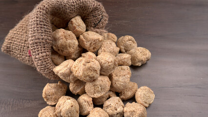 Raw soya chunks on dark background. Healthy, nutritious soybean meat, chunks isolated.Vegan food concept.