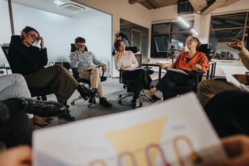 Group of coworkers having a lively discussion during a meeting in a modern office. The atmosphere is collaborative and productive, with diverse team members sharing ideas and opinions.