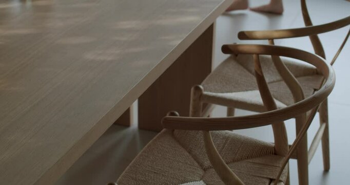 Modern dining room table and chairs made of light wood and woven natural fiber. Sunlight creates a calm and inviting atmosphere. Perfect for interior design, home decor, and lifestyle content.