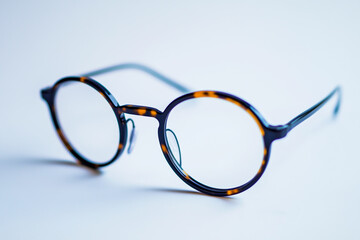 Round glasses with black frames and tortoiseshell lenses on a white background