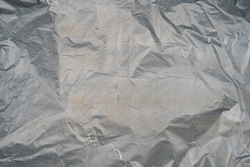 Close-up of textured silver crinkled fabric, emphasizing depth and patterns.