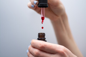 Woman holding open jar of liquid red vitamin B12 for body health and care