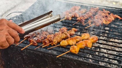 Grill Master Cooking Delicious Skewers Over Charcoal Flames at Outdoor Barbecue Event