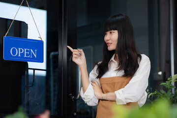 Owner of the cafe stands at the door with a sign Open waiting for customers. Small business concept, cafes and restaurants.