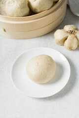 Overhead view of steamed bun on a white plate, top view of mantou on a white background, process of making steamed milk buns	