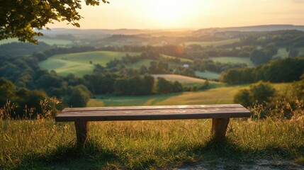 Obraz premium Empty wooden bench overlooking a picturesque valley at sunset.