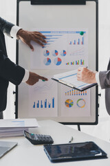 Businessman making a presentation at work in front of colleague. Businessman coach mentor explain graph chart on flipchart corporate group workshop training in meeting room.
