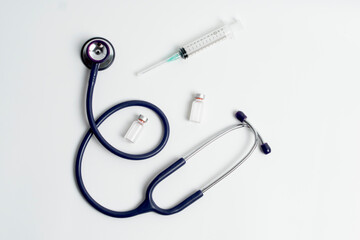 Medical layout on white background, flat. stethoscope or phonendoscope with test tube, bottle or ampoule, vaccine vial, syringe, copy space, space for text.