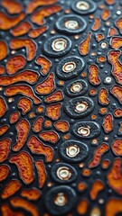 Closeup of a textured surface with orange and black organic shapes, resembling a pattern found on sea life