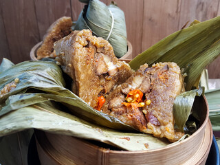 Zongzi (also known as Bakcang), savory glutinous rice dumplings, cut open to reveal the filling....