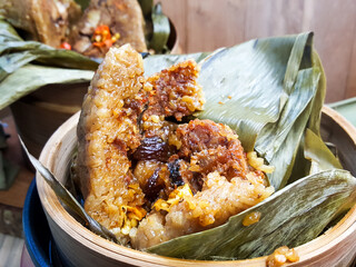 Zongzi (also known as Bakcang), savory glutinous rice dumplings, cut open to reveal the filling....