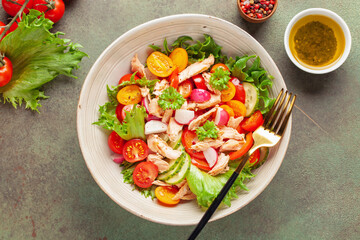 Salad with grilled salmon, fresh green  leaves, cucumber, tomatoes, sweet pepper and radish. Healthy lunch salad in bowl.