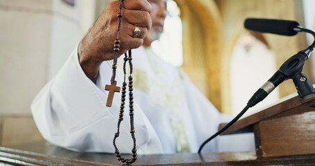 Rosary, hand and preacher praying in church as Christian for salvation, service and worship with faith. Religion, bishop and respect with man or praise for guidance, speech and spiritual ceremony