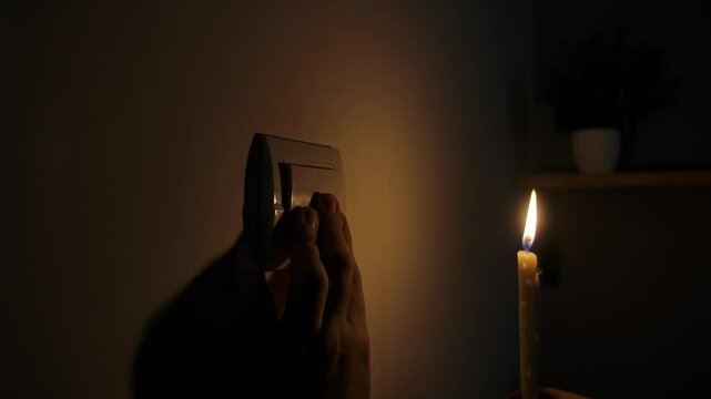 Hand Approaching Light Switch During Power Outage