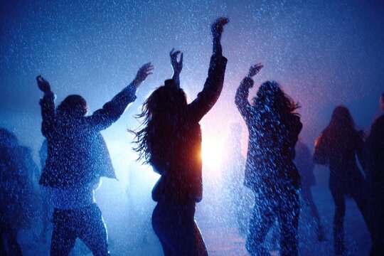 Dancing silhouettes in vibrant rain light