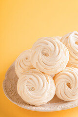 Homemade mango marshmallow on a plate with orange background