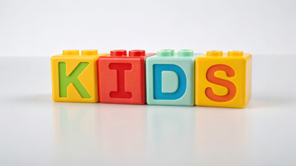 Colorful plastic toy blocks spelling "KIDS" on white background