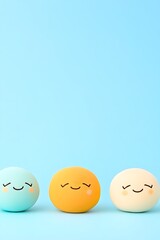 Three pastel-colored eggs with happy faces on a light blue background