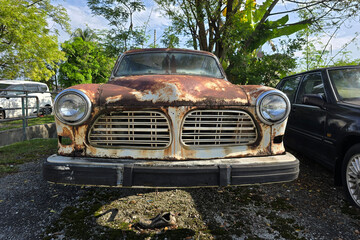 Front View of a Rusty Vintage Car Parked Outdoors