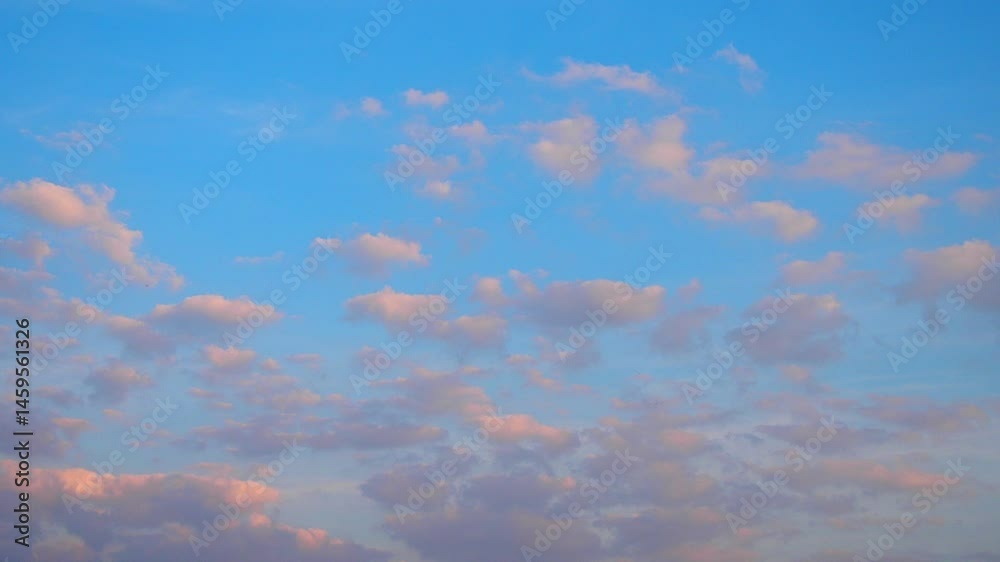 Poster Witness an enchanting display of nature as fluffy clouds painted in soft pastels are illuminated by the warm hues of the setting sun