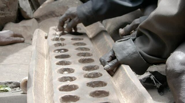 Close up shot of people playing mancala in a village in Ethiopia.