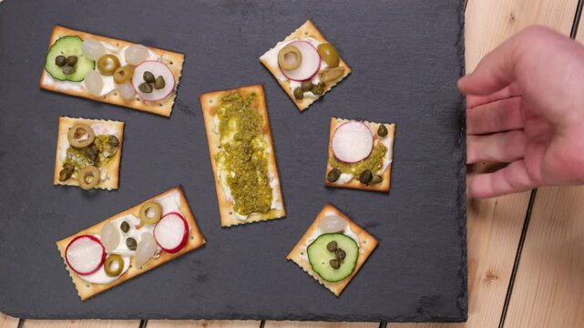 Uomo mette in tavola un tagliere con tartine miste