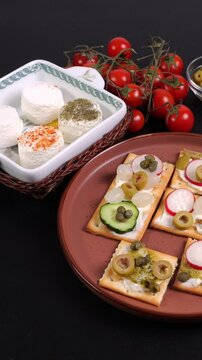 Video verticale, tartine di cracker, formaggio, pomodori, olive, capperi verdure, formaggi tomini nella ciotola