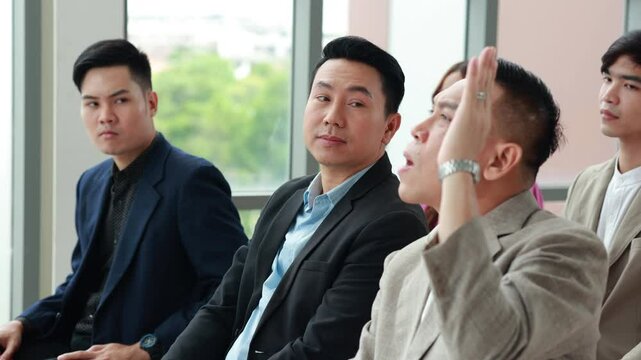 Question and answer audience or crowd : Active participation Asian man raise hands to ask questions attending seminar in conference meeting and training