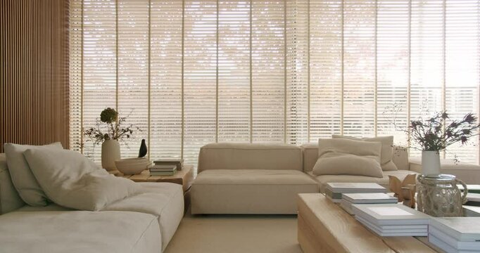 Bright, minimalist living room with large windows, wooden blinds, and comfortable sofas. The room is filled with natural light, creating a calming and peaceful atmosphere. home decor, interior design