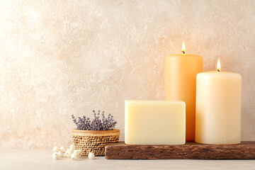 Aromatic soap and lavender sit near burning candles creating a spa environment indoors now.
