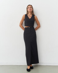Stylish woman showcases elegant fashion in a modern studio setting