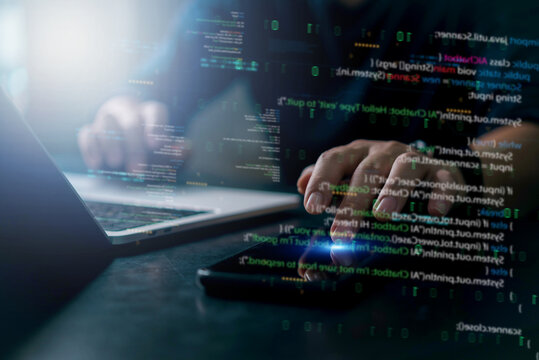 Developer coding in dark room with futuristic interface. Binary and source code reflections indicate system analysis and cyber intelligence. - Powered by Adobe