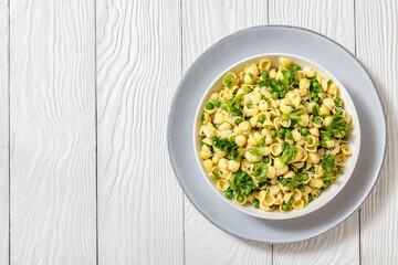 Pasta with green peas in a bowl, italian cuisine