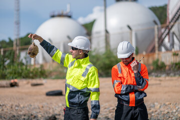 Environmental engineer or workers examining waste water along a  large industrial waste water or pollution monitoring and maintenance to ensure systems operate effective environmental regulations.