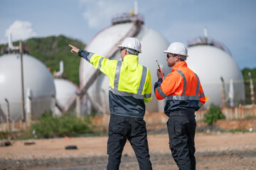 Environmental engineer or workers examining waste water along a  large industrial waste water or pollution monitoring and maintenance to ensure systems operate effective environmental regulations.