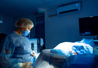Surgeon conducts delicate surgery. A surgeon and assistant are focused on a surgical operation in a...
