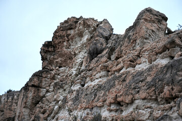 Majestic rocky cliff under cloudy sky capturing nature's rugged beauty