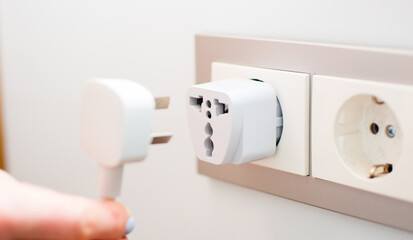 Universal travel adapter in a socket close-up
