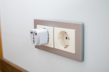 Universal travel adapter in a socket close-up