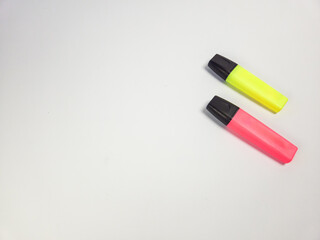Two bright colored highlighters isolated on a clean white background