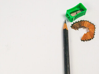 Sharpened Pencil, Green Sharpener, and Wood Shavings on White Background