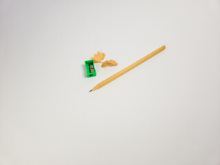 Pencil, sharpener, and shavings isolated on a clean white background