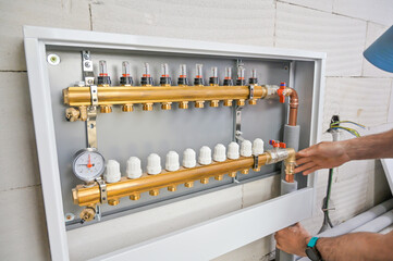 A dedicated plumber is carefully configuring a modern plumbing control setup, ensuring precise...