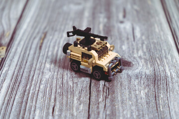 Toy military vehicle with machine gun resting on wooden surface
