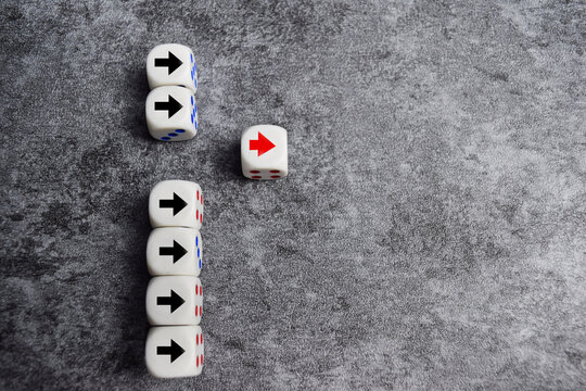 Wooden blocks or dice with arrows with one moving forward and standing out from the crowd. Concept of competitive advantage business startup