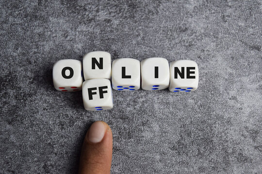 Going offline. To choose between online and offline. Digital detox male hand transforms the word online to offline on wooden cubes or dice