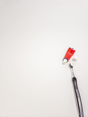 Toothbrush and toothpaste on a white surface, dental hygiene concept