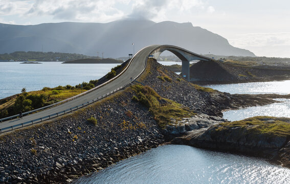 Atlantic Ocean Road with famous Storseisundet Bridge, modern highway engineering meets wild Norway nature, sunset view, scenic drive, coastal architecture, iconic travel destination